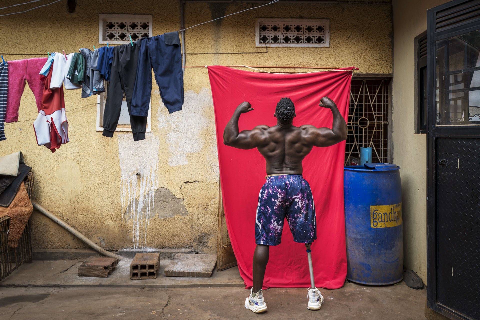 Bodybuilder Tamale Safalu trains in front of his home in Kampala, Uganda.